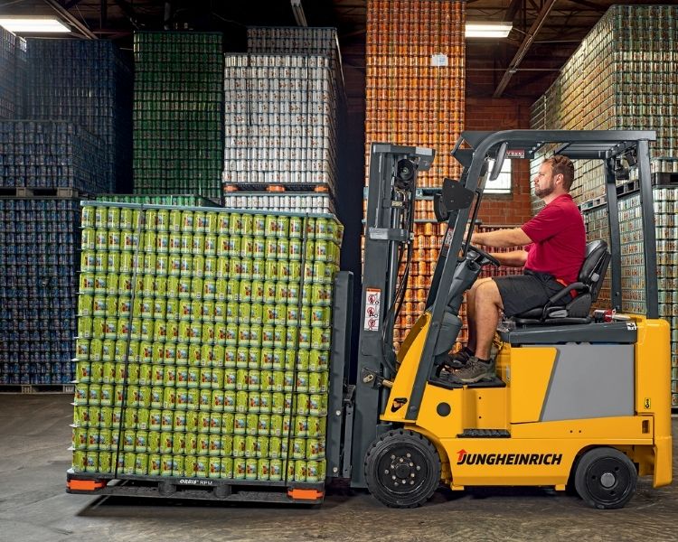 Jungheinrich 4-wheel sit-down electric forklift moving beer cans in a warehouse