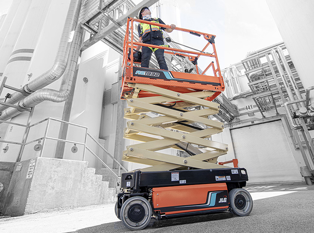 A JLG scissor lift at a refinery with one operator on the platform with scissors not extended.