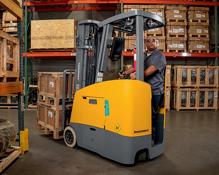 Stand-up forklift in a warehouse.